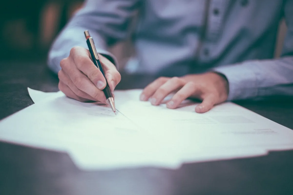 Persona revisando y firmando documentación para recursos administrativos en Asturias